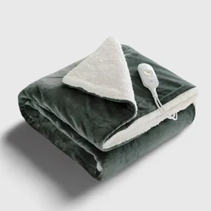 Couverture chauffante grise, moelleuse, pliée sur un canapé en tissu. Chaleur douillette et confort. #AccessoiresChauffants #CouvertureChauffante #Chaleur